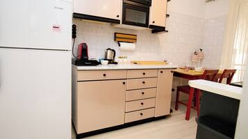 Een koelkast, een oven, een koffiezetapparaat/waterkoker, een waterkoker