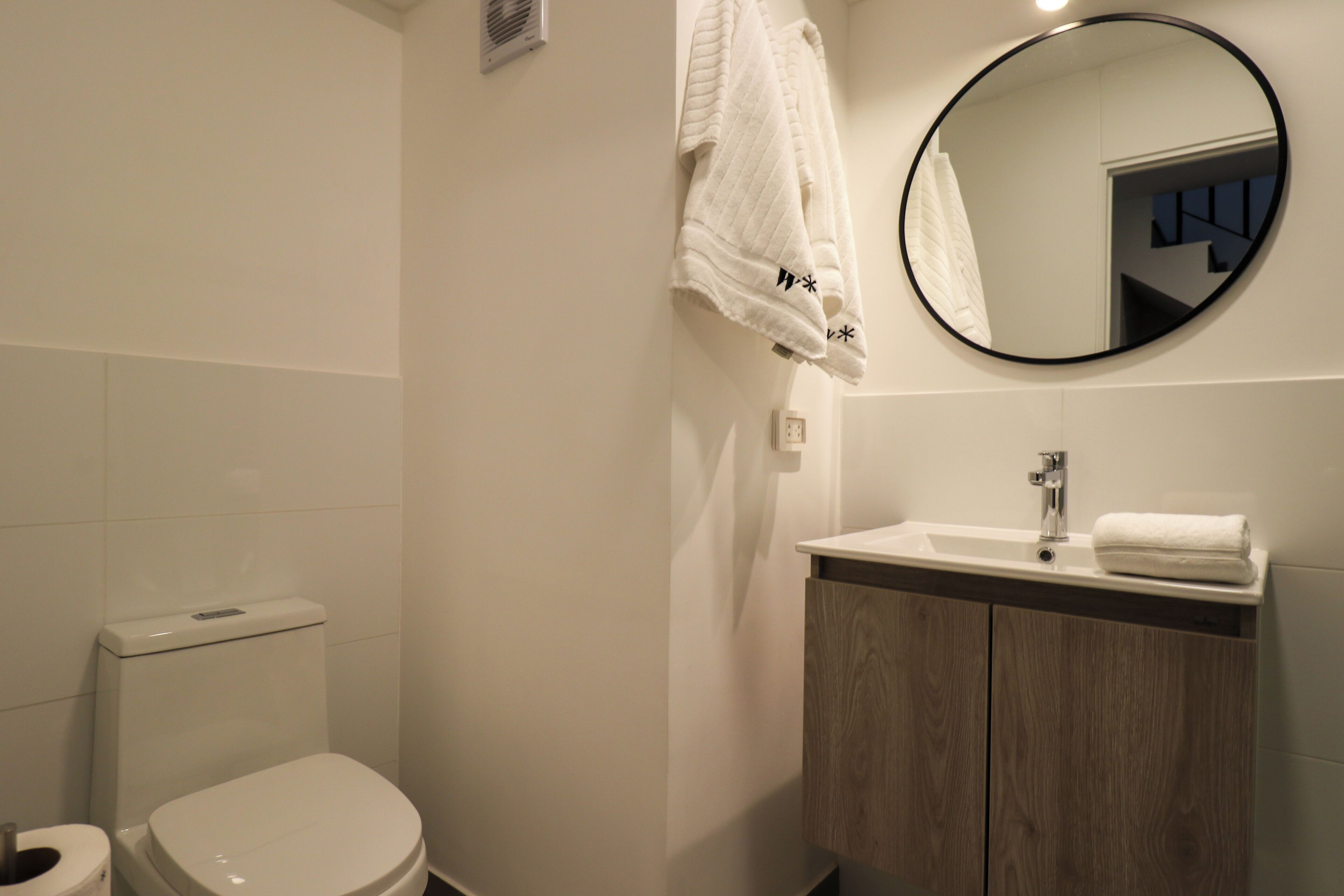 Et stilfuldt badeværelse med toilet, vask og spejl.