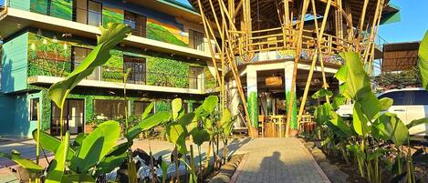 A building with a bamboo structure and a paved walkway.