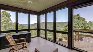 A spacious room with large windows offering a view of the surrounding landscape.