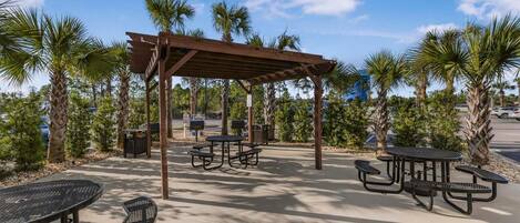 An outdoor patio area with picnic tables and a pergola.