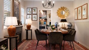 A dining area with a chandelier, framed artwork, and a decorative mirror.