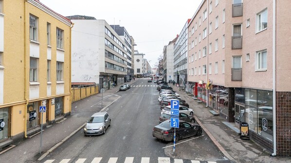 Une rue bordée de voitures garées, avec des immeubles et un passage piéton.