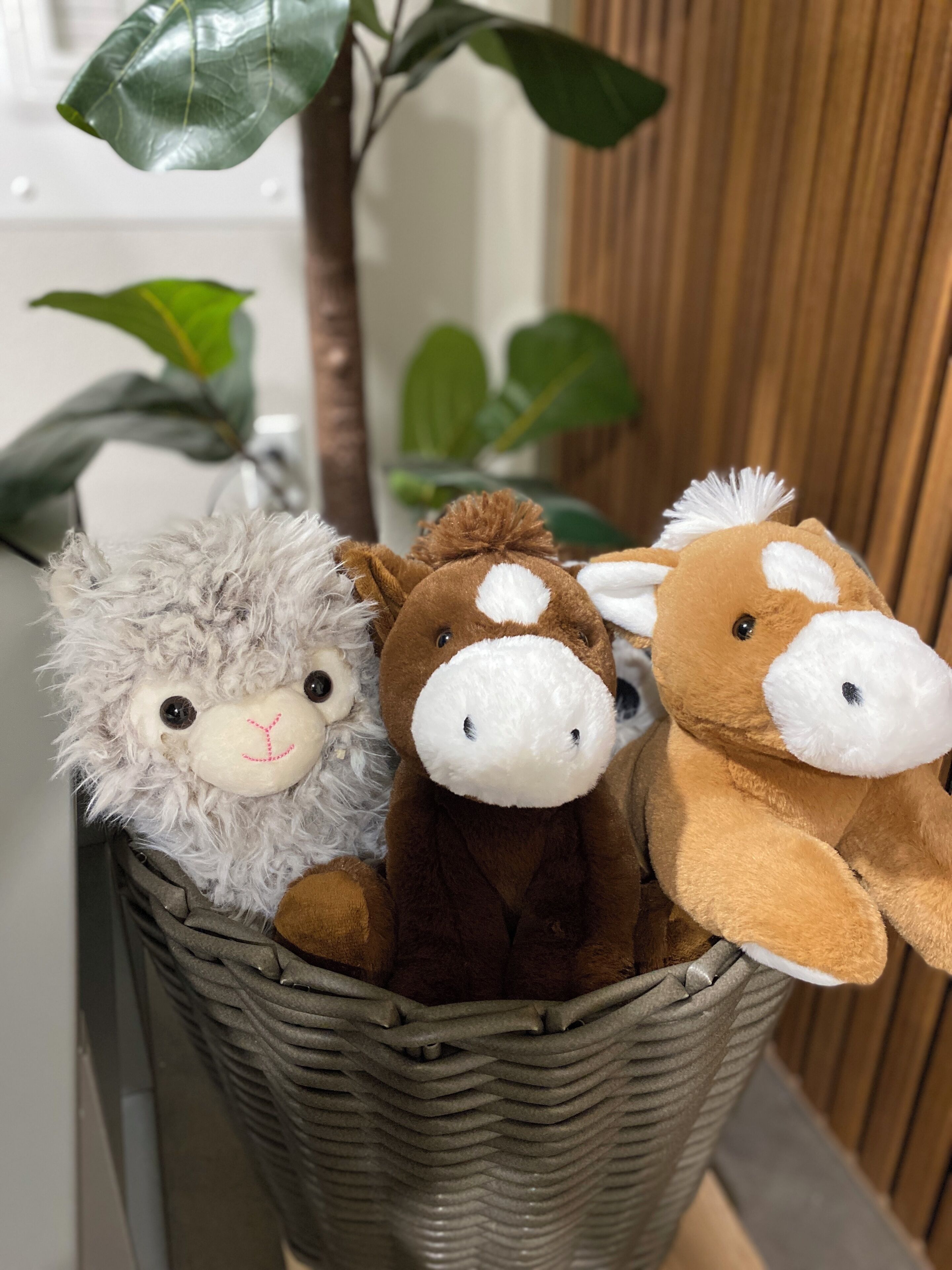 Un panier contenant trois peluches.