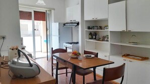 Una cocina compacta con mesa, sillas y horno empotrado.