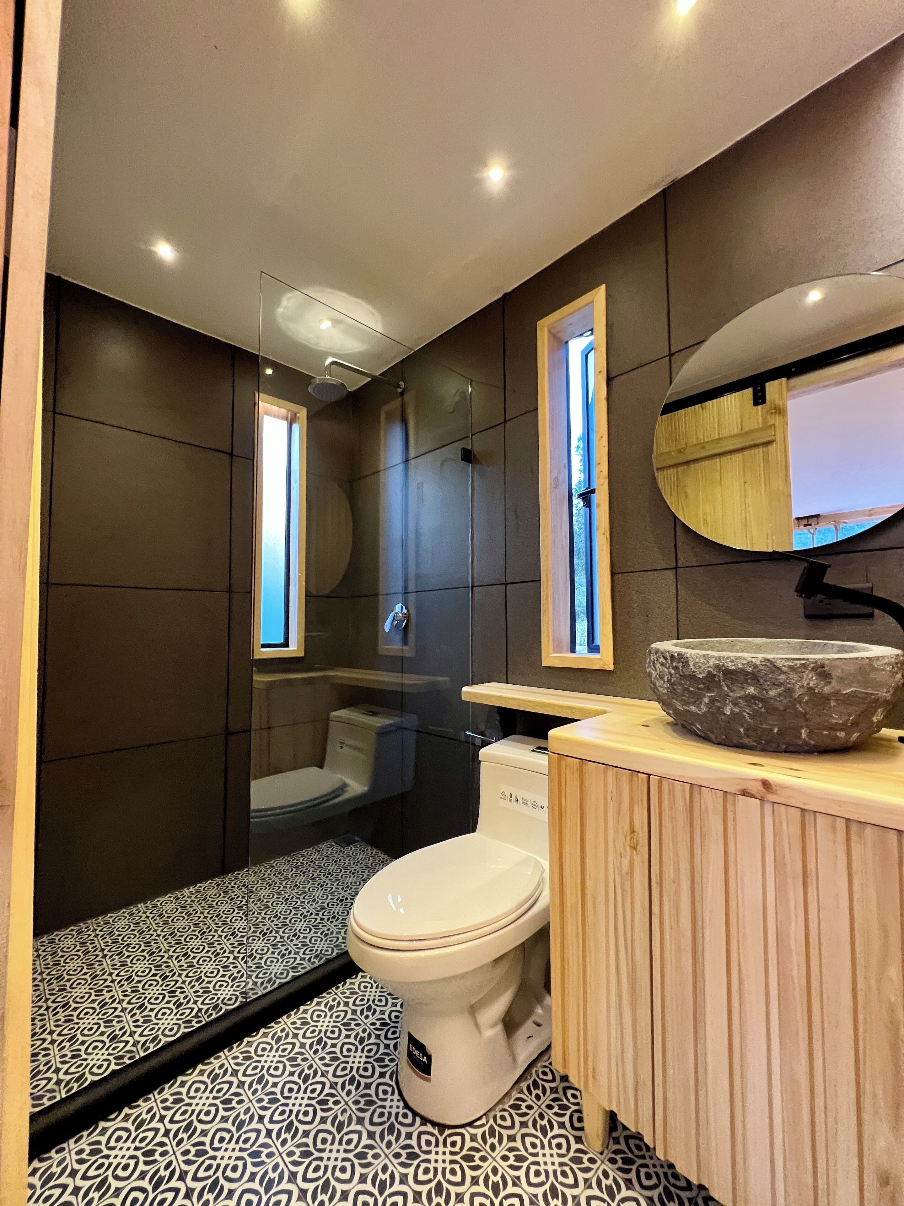 A modern bathroom with a shower, toilet, and sink.
