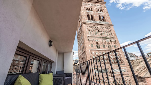 Un balcon offrant une vue sur une haute tour au design complexe et élaboré.
