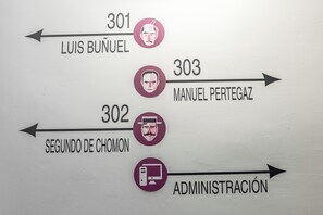 Ein Hinweisschild mit Nummern und Namen, das verschiedene Büros oder Abteilungen kennzeichnet.