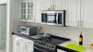 A modern kitchen with white cabinets, a microwave, an oven, and a sink. - Charming 3-bedroom villa with AC and WiFi in lovely Sebastian (Sebastian)