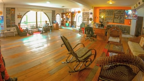 Un'ampia stanza con parquet, una scrivania della reception e un'area salotto con sedie e una poltrona a dondolo.