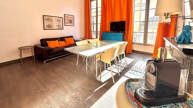 Un salon moderne avec un canapé, une table à manger et une machine à café.