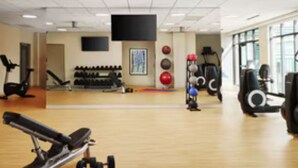 Une salle de sport équipée de matériel d’exercice, d’un téléviseur et d’un miroir.