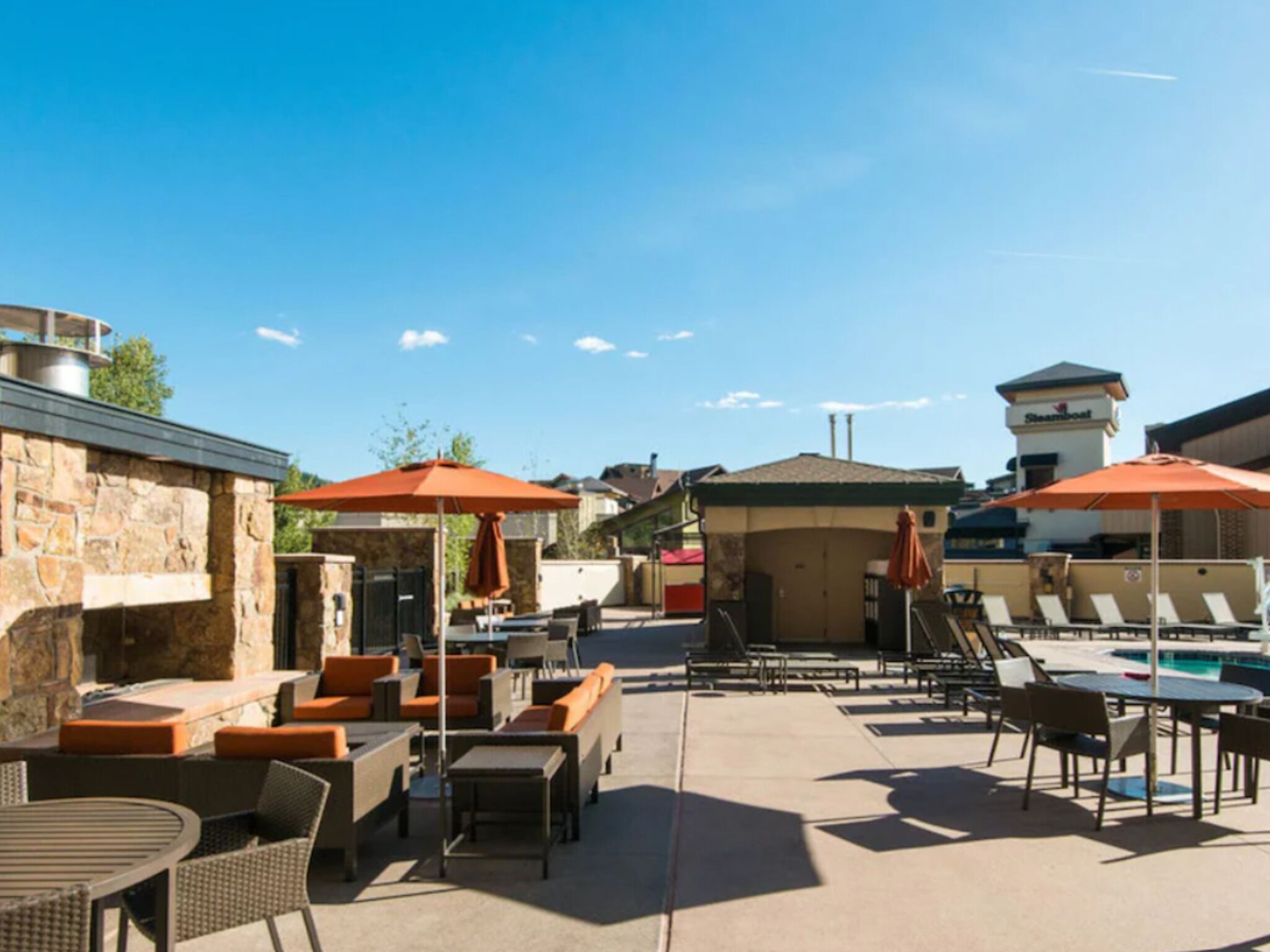 An outdoor patio area with seating, a pool, and a stone wall.