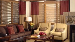 Un salon comprenant un canapé, deux fauteuils, une table basse, une lampe et une cheminée.