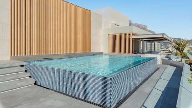 A rooftop infinity pool with a clear view of the city skyline.