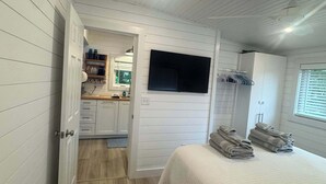 Ein Schlafzimmer mit einem Bett, einem Kleiderschrank und einer kleinen Küchenzeile.