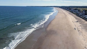 A beach with a sandy shore and a clear view of the ocean.