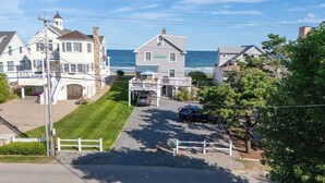 A coastal residential area with houses, a clear sky, and the ocean in the background.