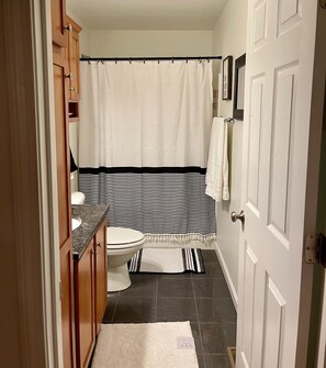 Une petite salle de bain comprenant des toilettes, un rideau de douche et un porte-serviettes.