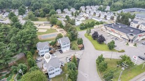 An aerial view of a residential area with houses, a playground, and a gas station.