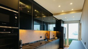 A modern kitchen with a long countertop, built-in appliances, and a view through the window.