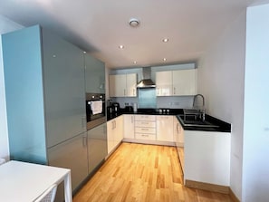 A modern kitchen with a built-in oven, a sink, and a stove.