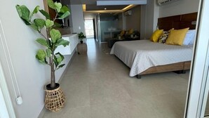 Una habitación de hotel moderna con una cama, una mesita de noche y una planta en maceta.