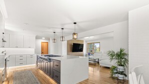 A modern kitchen with white cabinetry, a central island, and pendant lighting. - Charming 4 bedroom, 3 bathroom Brick Home located on 3 rural acres. (Colton)