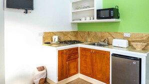 Cocina compacta con estufa a gas, pileta, microondas y lavavajillas.