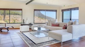 A spacious living room with a large window offering a view of a rocky landscape.