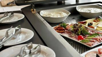 Un buffet proposant une variété de plats et d'ustensiles.