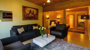 A modern living room with a black sofa, a white coffee table, and a painting on the wall. - Seeblick Hotel und Restaurant Rössli (Quarten)