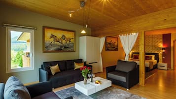 A modern living room with a sofa, armchairs, a coffee table, and a painting of horses.