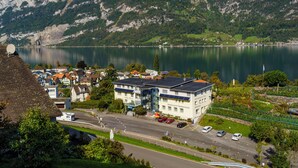 A hotel with a modern design, located near a lake with mountains in the background. - Seeblick Hotel und Restaurant Rössli (Quarten)