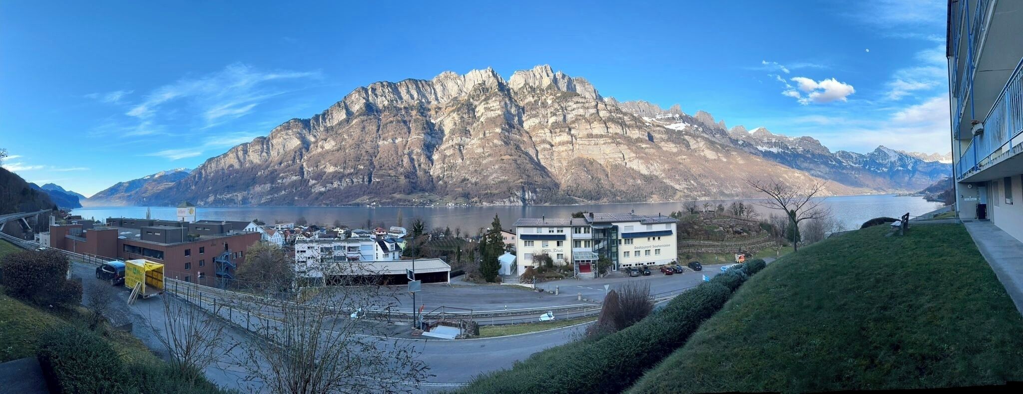 Ein Berg, im Vordergrund das Restaurant "Restaurant Seeflue", ein Parkplatz und im Hintergrund ein Gewässer.