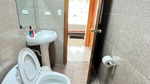 Une salle de bain avec des toilettes, un lavabo et un miroir.