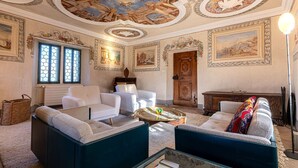 A spacious living room with a high ceiling, ornate ceiling artwork, and classical paintings on the walls. - Supersaxo QUIET & CHARMING chalet 10 pers (Veysonnaz)
