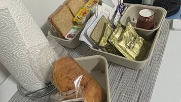 A tray with bread, butter, jam, and a cake.