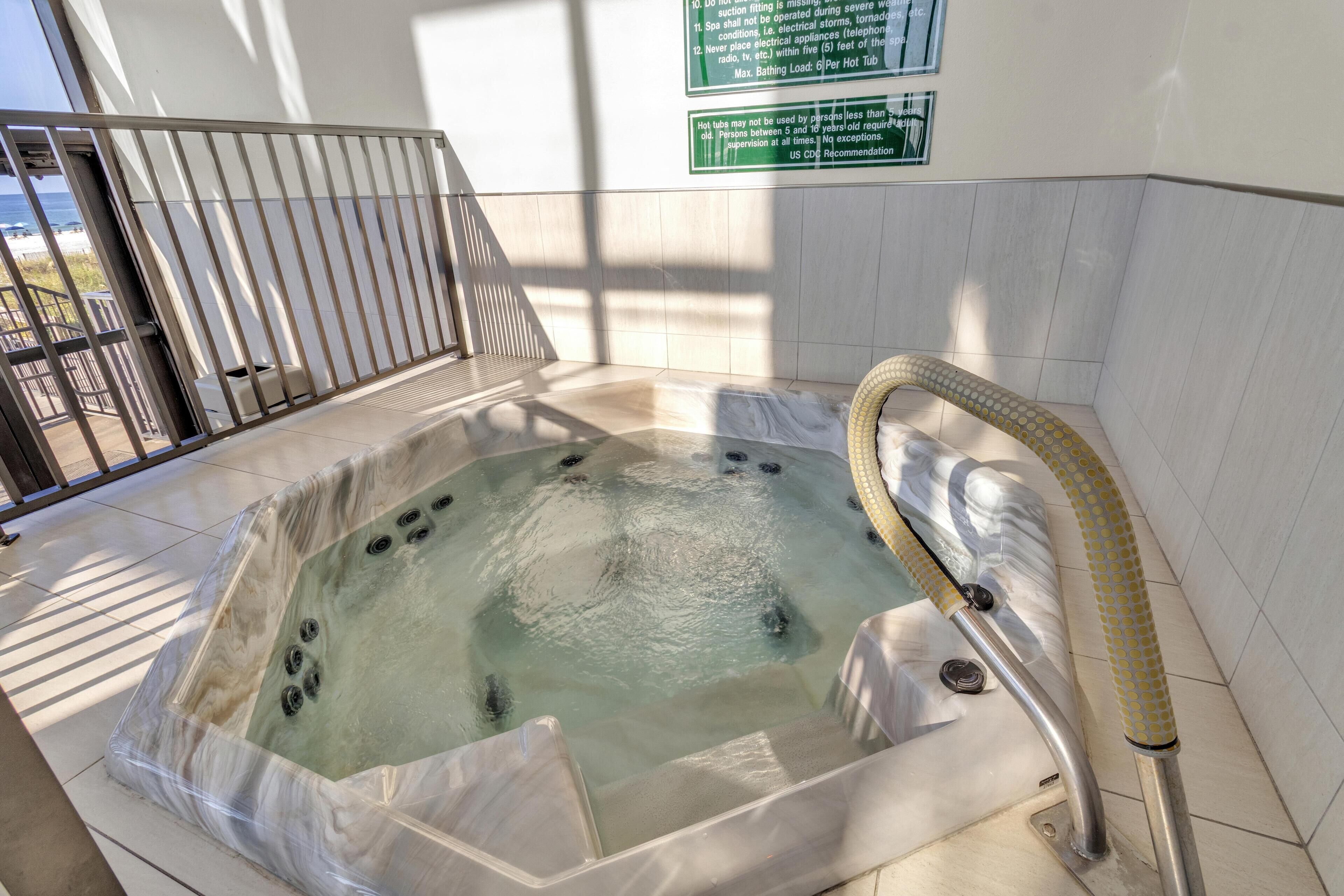 Een hottub met een veiligheidsreling en een bord met veiligheidsvoorschriften.