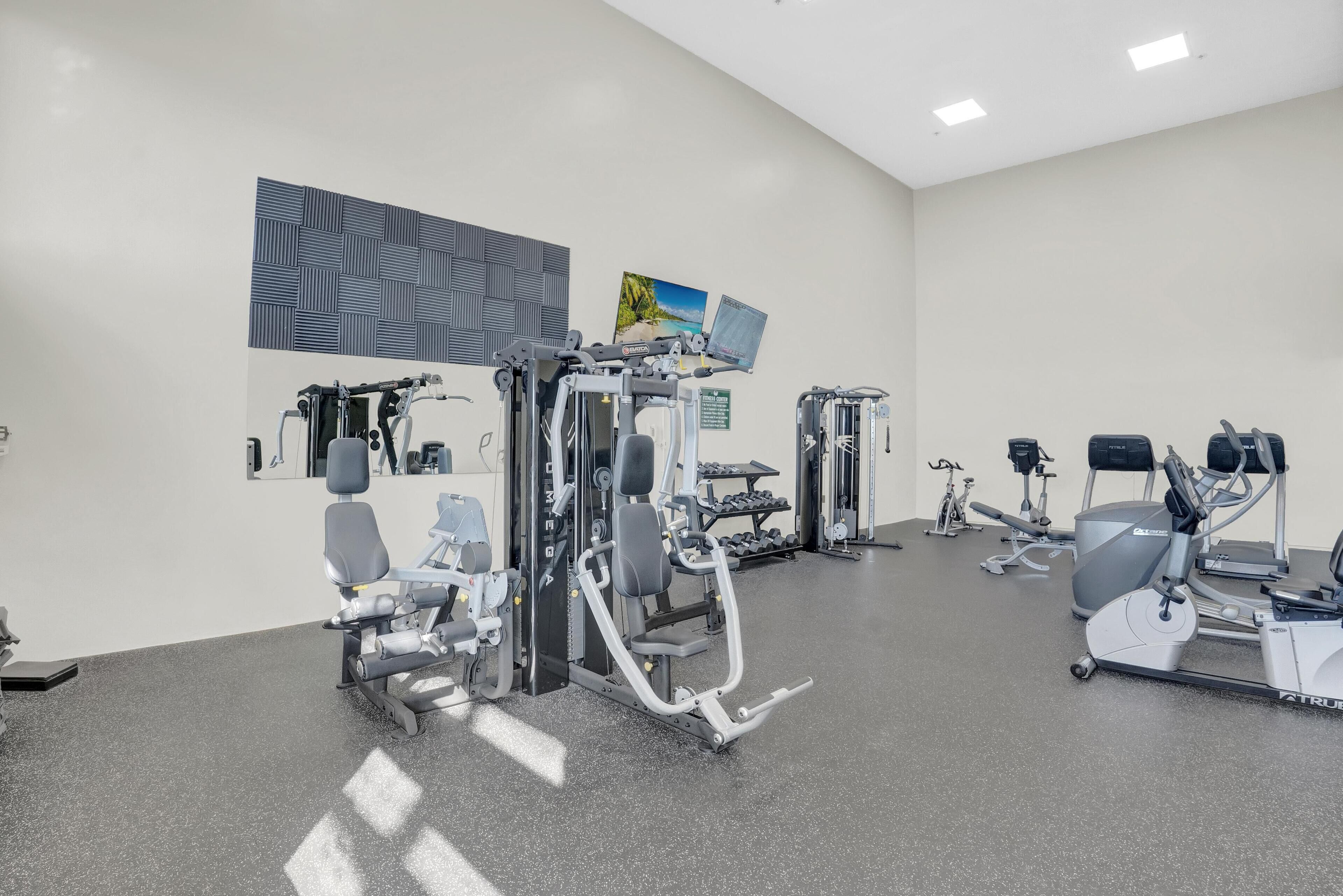 Une salle de sport moderne équipée de divers appareils d’entraînement, notamment des appareils de musculation et des appareils de cardio.