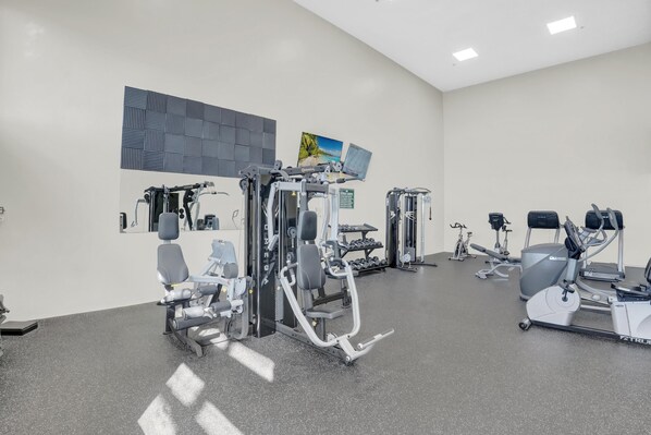 Une salle de sport moderne équipée de divers appareils d’entraînement, notamment des appareils de musculation et des appareils de cardio.