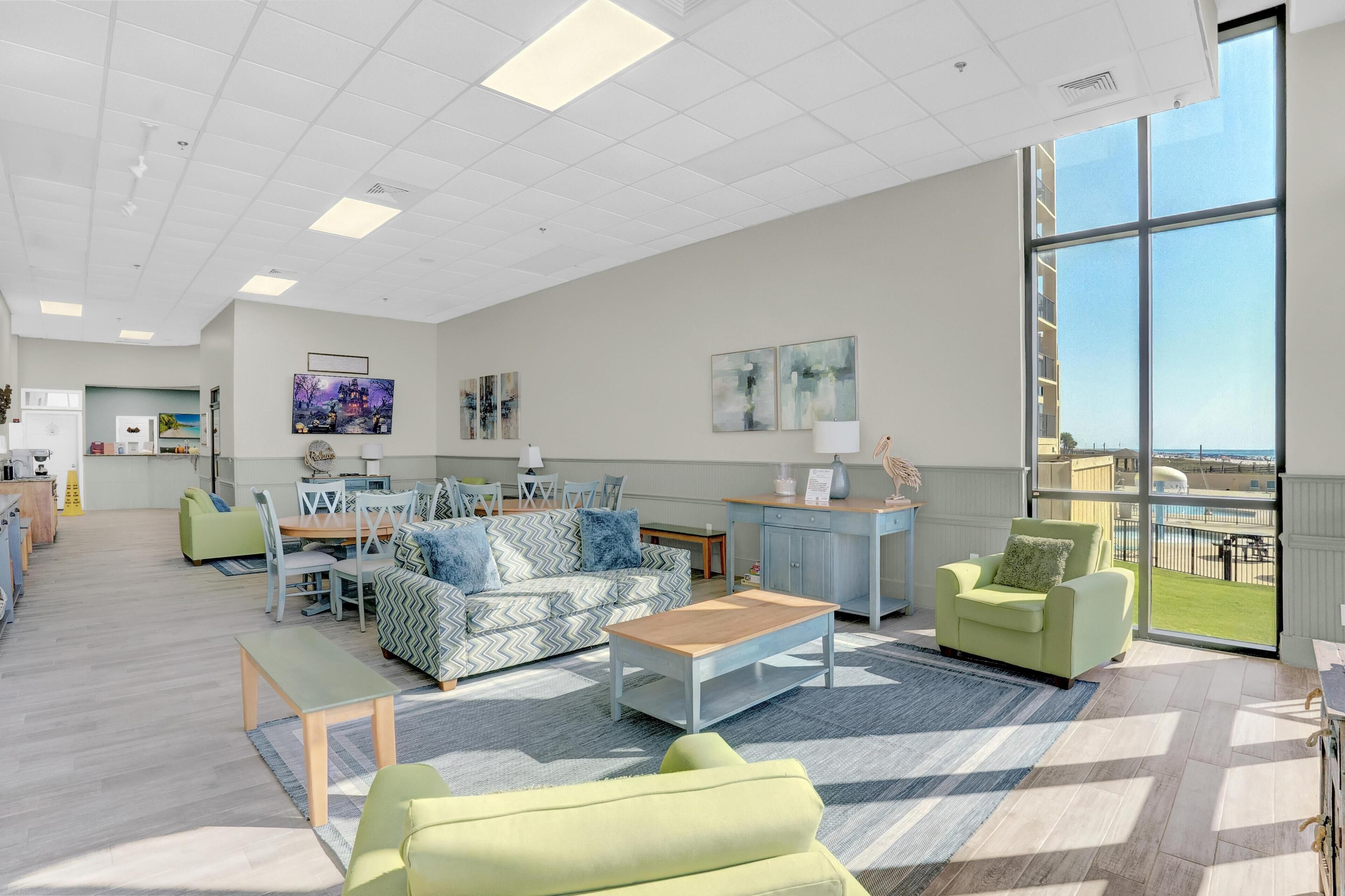 A spacious living area with a large window, a dining table, and a sofa.