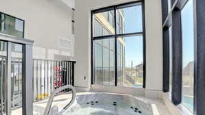 A modern indoor hot tub with a view of the city through large windows. - Phoenix I 1097 (Orange Beach)