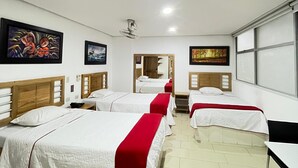 A hotel room with four beds, a ceiling fan, and artwork on the walls. - Hotel Portal Central (Itagüí)