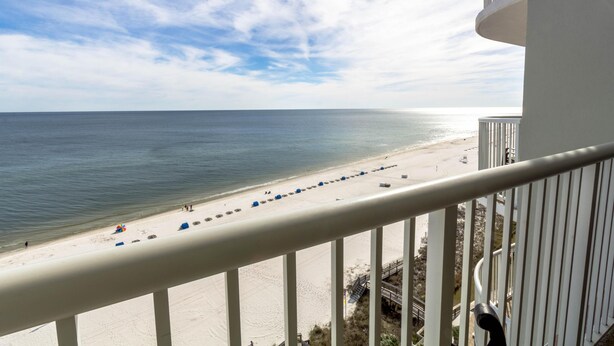 Un balcon avec vue sur une plage et l’océan.
