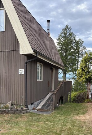 A two-story building with a dark brown exterior, a chimney, and a small porch with a ramp leading to the entrance. - Charming, dog-friendly cabin in peaceful Birch Bay, Wa (Blaine)