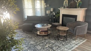 A living room with a sofa, armchairs, a coffee table, and a fireplace. - Spacious 3-bedroom house with AC, fitness room, WiFi in Leander/North Austin (Leander)