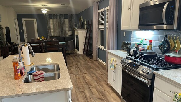 A modern kitchen with a stove, microwave, and sink. - Spacious 3-bedroom house with AC, fitness room, WiFi in Leander/North Austin (Leander)