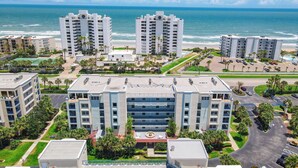 A high-rise hotel with multiple floors, a central courtyard, and a view of the ocean.