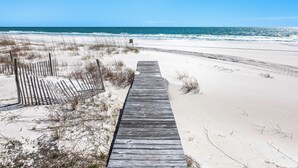 A wooden boardwalk leading to a beach with sand dunes and a clear blue sky. - 5-Bed Beach House with Private Pool (Panama City Beach)